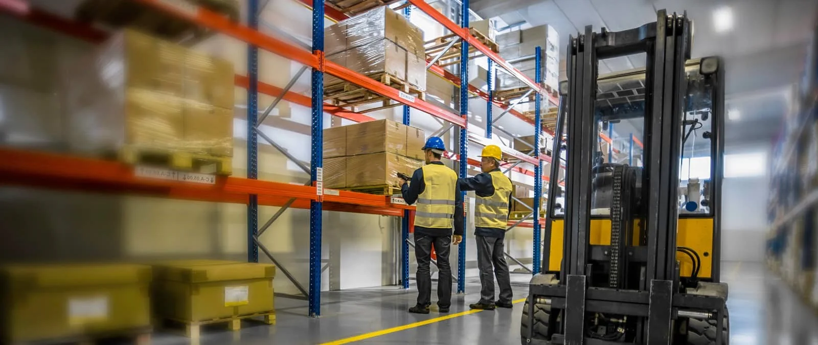Medewerkers en heftruck in een distributiecentrum